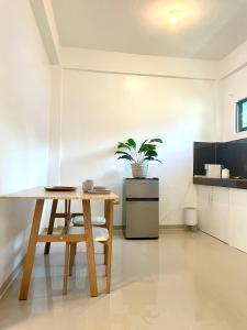 a kitchen with a wooden table and a plant at Namal Apartelle - Free Scooter & Concierge Service in El Nido