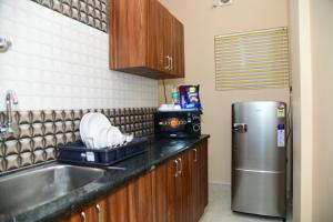 een keuken met een wastafel en een koelkast bij 1 RK AC Room with Open Terrace Manyata Tech Park in Bangalore