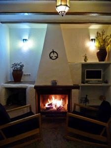 sala de estar con chimenea y reloj en la pared en Cortijo Leontino, en Taberno