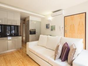 sala de estar con sofá blanco y cocina en InSitu Trindade by Guestify, en Oporto