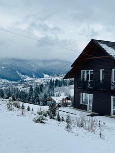 una casa en la cima de una montaña cubierta de nieve en Мелодія Гір Вид на гори, en Vorokhta