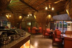 a restaurant with a bar and tables and chairs at DAN Resorts & Weddings in Boisar