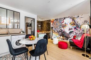 a kitchen and living room with a table and chairs at Cachette Secrète & SPA Narbonne in Narbonne