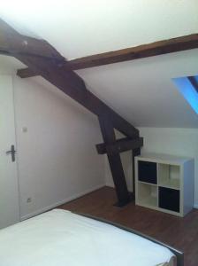 een kamer met een bed en een houten plafond bij Au Bel Yvonne in Hagondange