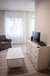 una sala de estar con TV en una cómoda blanca en Oskola Luxury Apartment en Szeged