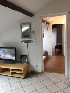 een woonkamer met een flatscreen-tv en een tafel bij Au Bel Yvonne in Hagondange