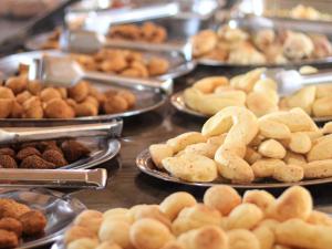 uma exposição de diferentes tipos de donuts e outros produtos de pastelaria em Ranchos 30 Hotel Fazenda em Hidrolândia
