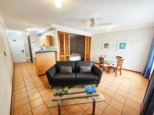 uma sala de estar com um sofá e uma mesa em Royal Palm Villas em Cairns