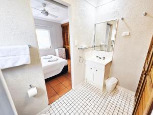 a white bathroom with a bed and a sink at Royal Palm Villas in Cairns +29 photos