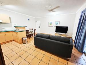 uma sala de estar com um sofá e uma cozinha em Royal Palm Villas em Cairns