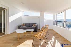 ein Wohnzimmer mit einem Sofa und Stühlen in der Unterkunft la grande vue exceptionnelle wifi in Bagnols-en-Forêt