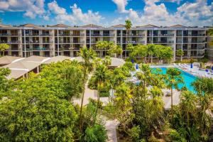 an aerial view of a resort with a pool and trees at Papaya Place by AvantStay Great Location w Balcony Outdoor Dining Shared Pool Hot Tub in Key West