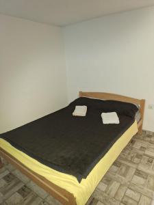 a bed with two towels on top of it at Apartman Jaca 