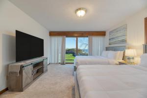 um quarto de hotel com duas camas e uma televisão de ecrã plano em Bay Cottage by AvantStay Waterfront Pier Pond em Ridge