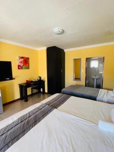 una grande camera da letto con un grande letto e una scrivania di LOVIC GUEST HOUSE +27655256611 a Mahikeng