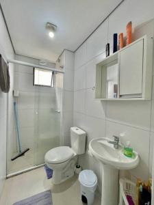 a bathroom with a toilet and a sink and a shower at champs frente mar ao sol in Balneário Camboriú