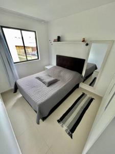 a small bedroom with a bed and a window at champs frente mar ao sol in Balneário Camboriú