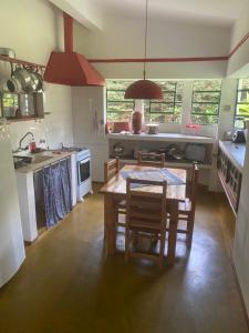 a kitchen with a table and chairs in a room at Sitio-Estalagem Purioca in Cunha