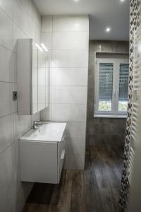 biała łazienka z umywalką i oknem w obiekcie Attila Luxury Apartment w Segedynie +21 zdjęć