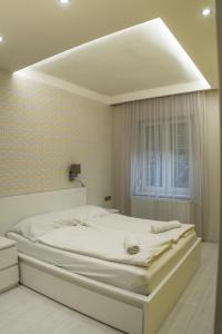 biała sypialnia z dużym łóżkiem w pokoju w obiekcie Attila Luxury Apartment w Segedynie