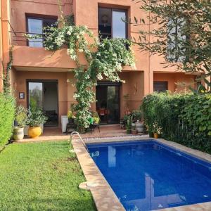een huis met een zwembad in de tuin bij TOP Villa Pavillon dans Golf à 20 min de Marrakech in Sraghna