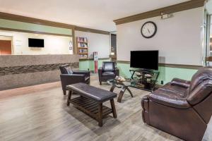 a waiting room with leather furniture and a flat screen tv at Days Hotel by Wyndham Danville Conference Center in Danville