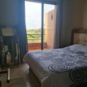 een slaapkamer met een bed en een groot raam bij TOP Villa Pavillon dans Golf à 20 min de Marrakech in Sraghna