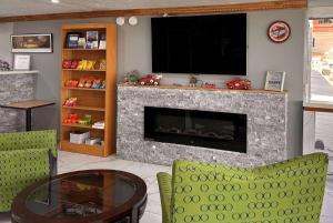 a living room with a fireplace with a flat screen tv at Travelodge by Wyndham Bloomington in Bloomington