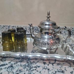 een zilveren theeservies op een tafel met glazen bij TOP Villa Pavillon dans Golf à 20 min de Marrakech in Sraghna