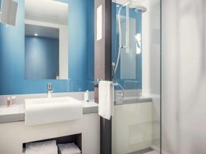 La salle de bains est pourvue d'un lavabo et d'une douche. dans l'établissement Mercure Paris Val de Fontenay, à Fontenay-sous-Bois