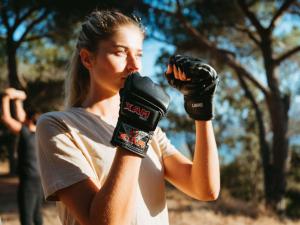 a woman holding up a pair of boxing gloves at Sofitel Golfe d'Ajaccio Thalassa Sea & Spa in Ajaccio