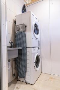 a washing machine and a washer and dryer in a bathroom at Jagodowa Osada in Dzianisz