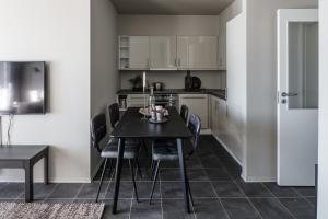 a kitchen and dining room with a black table and chairs at Høyfjellsgrend 962 in Trysil