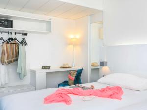 a bedroom with a bed with a pink robe on it at Ibis Styles Menton Centre in Menton