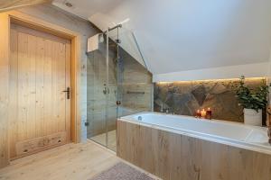 a large bathroom with a tub and a shower at Jagodowa Osada in Dzianisz