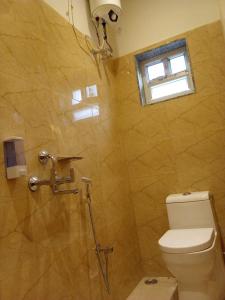 a bathroom with a shower with a toilet and a window at HOTEL SKYKING in Gauripur +22 photos