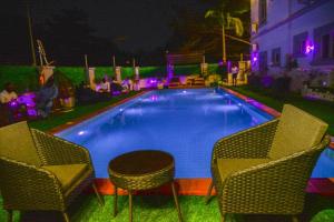 a swimming pool with two chairs and a table at SS3 Jabi Hotel in Abuja
