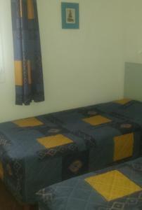 1 dormitorio con 2 camas individuales y pared en Hôtel du Château Fort, en Lourdes