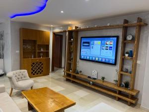 ein Wohnzimmer mit einem großen Flachbild-TV an der Wand in der Unterkunft ENNADOUR 1 in Mahdia