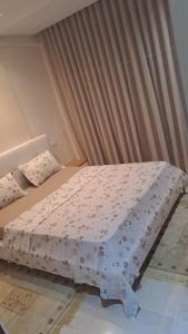ein Schlafzimmer mit einem Bett mit einer weißen Bettdecke in der Unterkunft ENNADOUR 1 in Mahdia