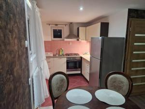 a small kitchen with a table and a refrigerator at Apartmánový dom v Panoráma Parku in Nezbudská Lúčka