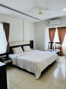 ShravanabelagolaSDK Residency的卧室里有一张铺着白色床单的大床