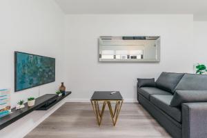 een woonkamer met een bank en een tafel bij Grace at Mosman Apartments in Sydney