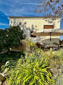 un patio con mesa y sombrilla en Casa Rural Girasoles Calig REF. 046, en Castellón de la Plana