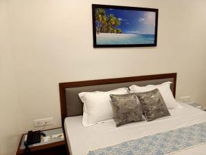 Srushti Sea Villa Resort في دايف إيغار: غرفة نوم بسرير مع صورة على الحائط