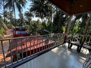 un balcón con un banco y un tren en una calle en Srushti Sea Villa Resort, en Diveagar