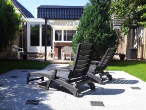 two chairs sitting on a patio in a yard at Bed & Kitchen Den Oever in Den Oever