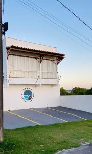 um edifício branco com uma janela e um parque de estacionamento em Hanuá Beach House em Guarapari
