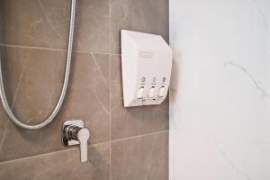 La salle de bains est pourvue d'une douche et d'un téléphone. dans l'établissement Grace at Mosman Apartments, à Sydney