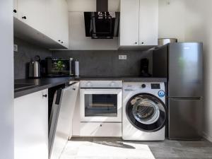 a kitchen with a washing machine and a refrigerator at # VAZ Apartments E01 Küche, TV, Netflix, ca 15 Min Messe u HBf in Essen